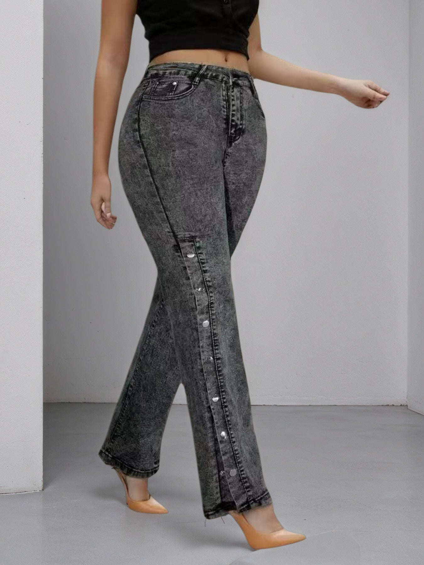 High-waisted dark jeans, slightly flared leg, side buckle accents on outer seam