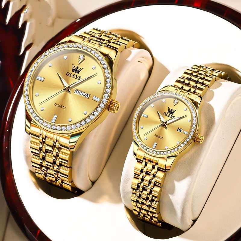 Pair of gold dial diamond bezel watches with gold metal link bracelets on display