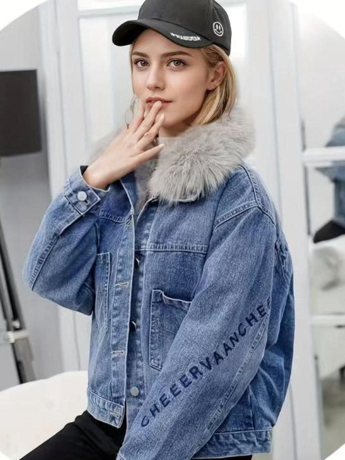 Light blue denim jacket with gray faux fur collar and logo print on sleeve