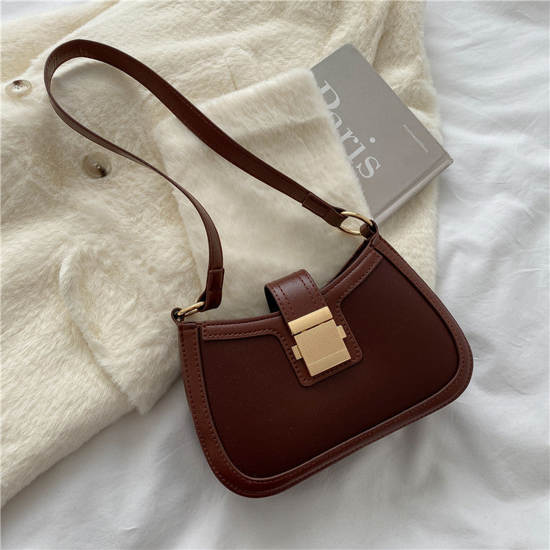 Brown PU shoulder bag with gold-tone clasp, adjustable strap and smooth curved body.