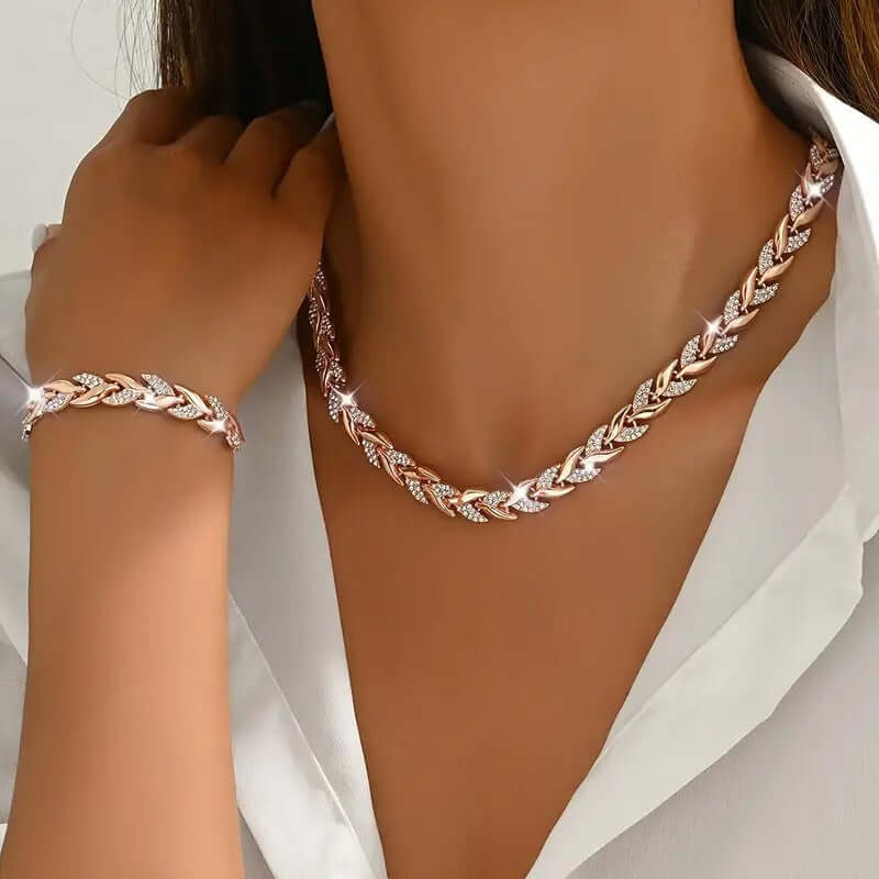 Rhinestone leaf necklace and bracelet set in rose gold tone, on model with linked chain pattern.