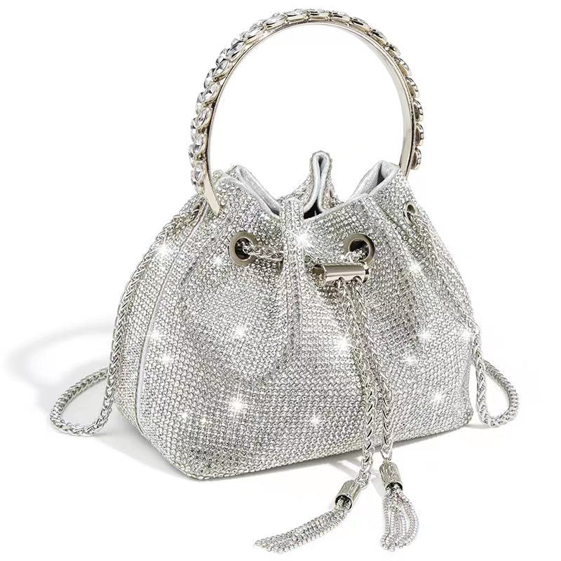 Silver rhinestone bucket bag with ring handle, drawstring closure, and tassels