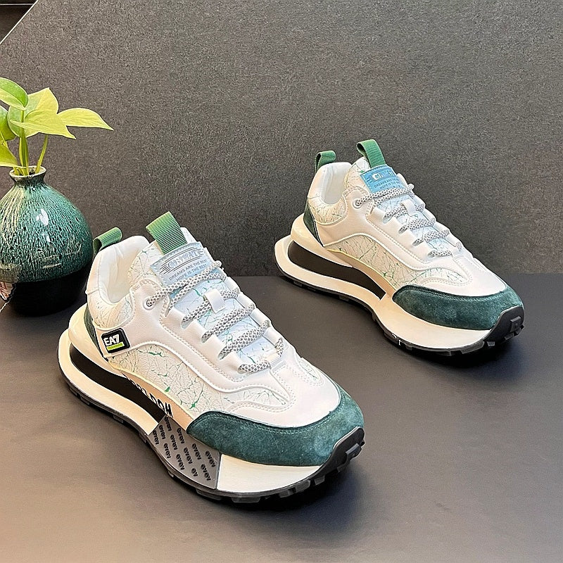 White sneakers with dark green toe and side panels, teal tongue label, and chunky sole