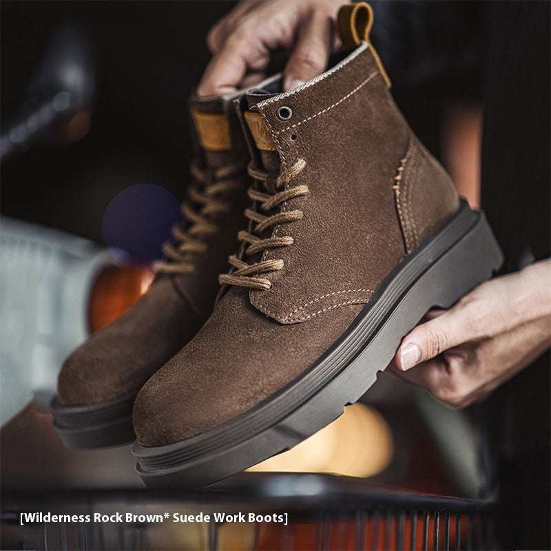 Brown suede work boots being held with a blurred background