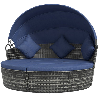 Outdoor rattan sunbed with retractable dark blue canopy and three navy pillows