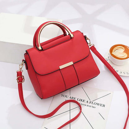 Red crossbody bag with top handle, flap front, gold-tone lock, and shoulder strap