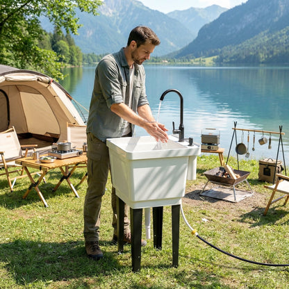 White portable utility sink with black faucet being used for hand washing outdoors