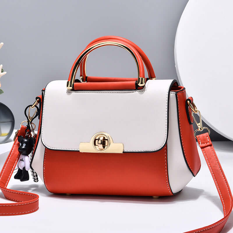 Two-tone crossbody handbag with gold clasp, top handle, red shoulder strap