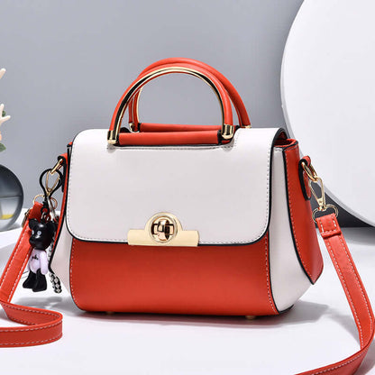Two-tone crossbody handbag with gold clasp, top handle, red shoulder strap