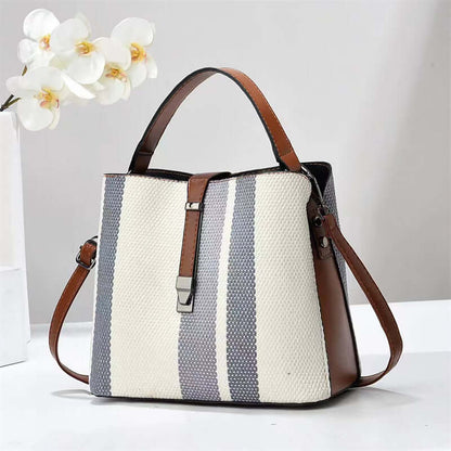 Large crossbody handbag in white and slate-blue vertical stripes with brown shoulder strap