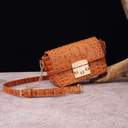 Orange croc-textured one-shoulder crossbody bag with flap and gold-tone lock