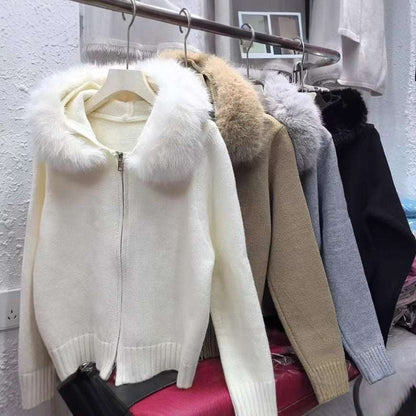 White sweater with fur hood on a hanger against a clothing rack background