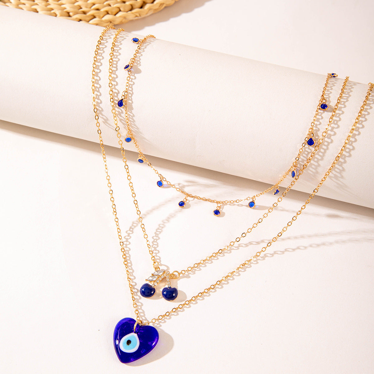 Multilayer pearl necklace with blue bead charms and gold-toned chains, heart pendant