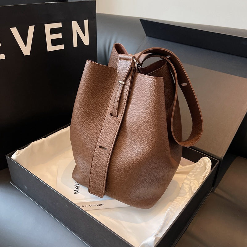 Pebble-grain bucket bag in tan with drawstring top and loop handle strap
