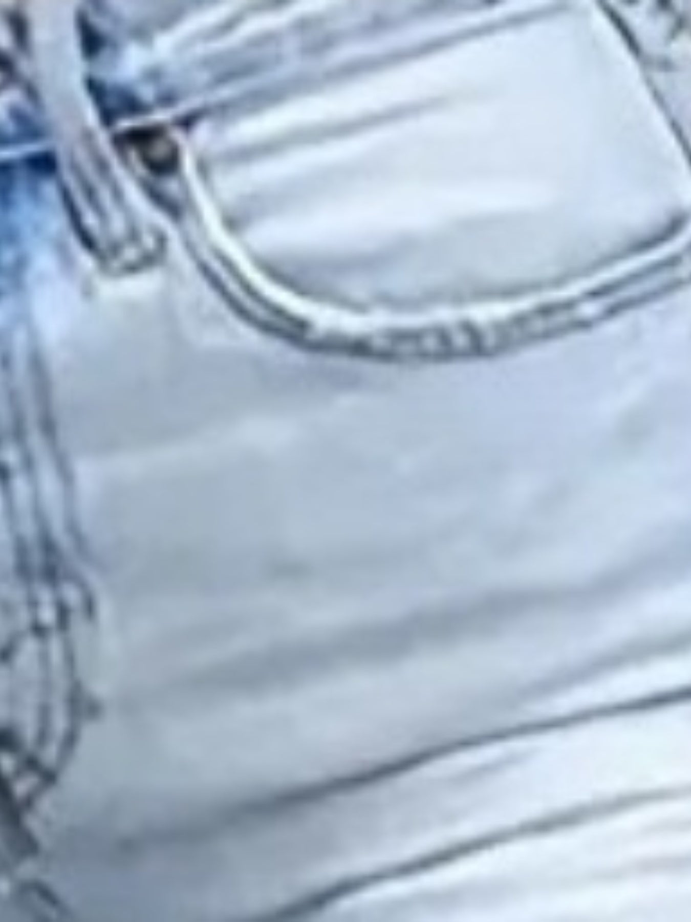 Light wash denim jeans close-up of waistband stitching and front seam