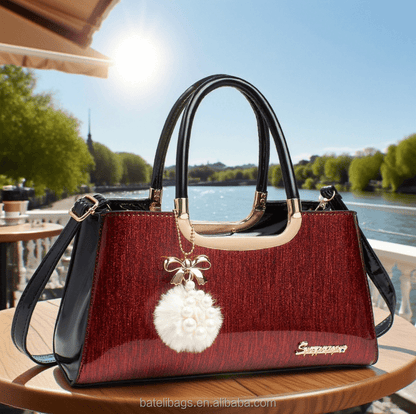 Structured glitter tote handbag in red with black handles and white pom-pom charm