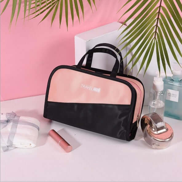 Cosmetic storage bag with clear front window, black body, and top carry handle.