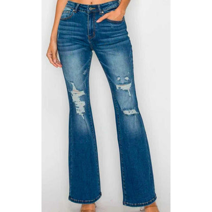 High-waist ankle jeans close-up in medium blue wash with patchy distress and wide leg