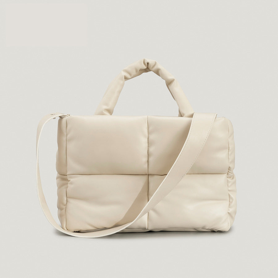 Beige puffy one-shoulder handbag with quilted panels and wide crossbody strap