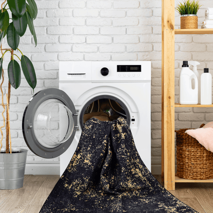 Black and gold speckled washable runner rug laid over washer opening.