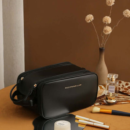 Black cosmetic bag with double zippers and gold-tone zipper pulls