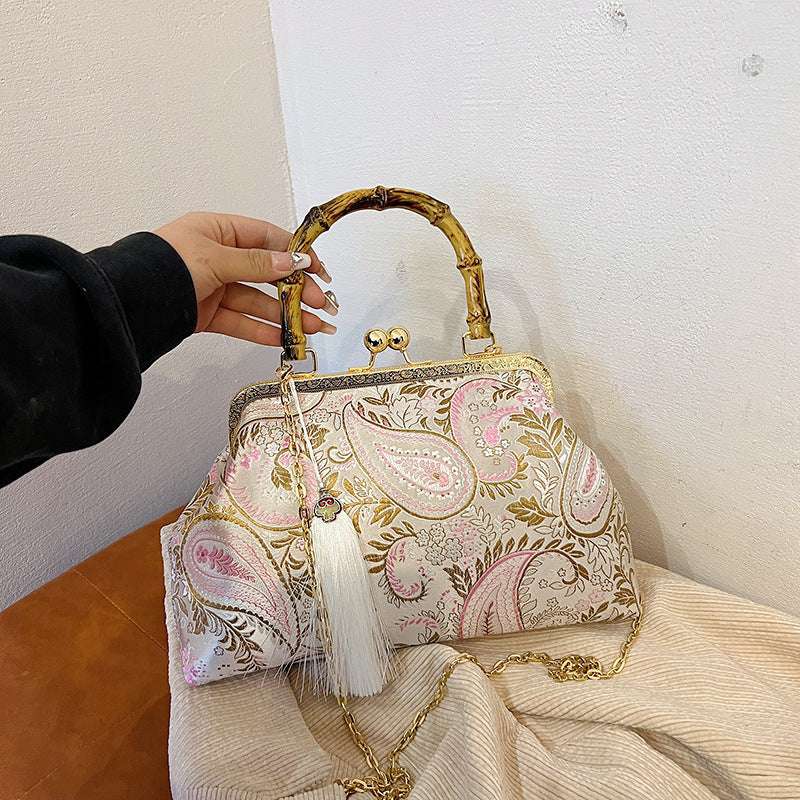 Ivory paisley satin clutch with bamboo handle, frame clasp, white tassel and gold chain