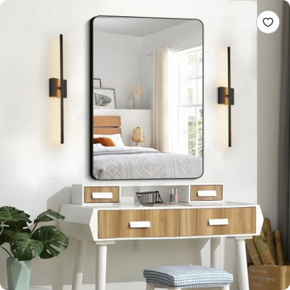 Black LED wall sconces flanking round mirror, slim vertical light bars