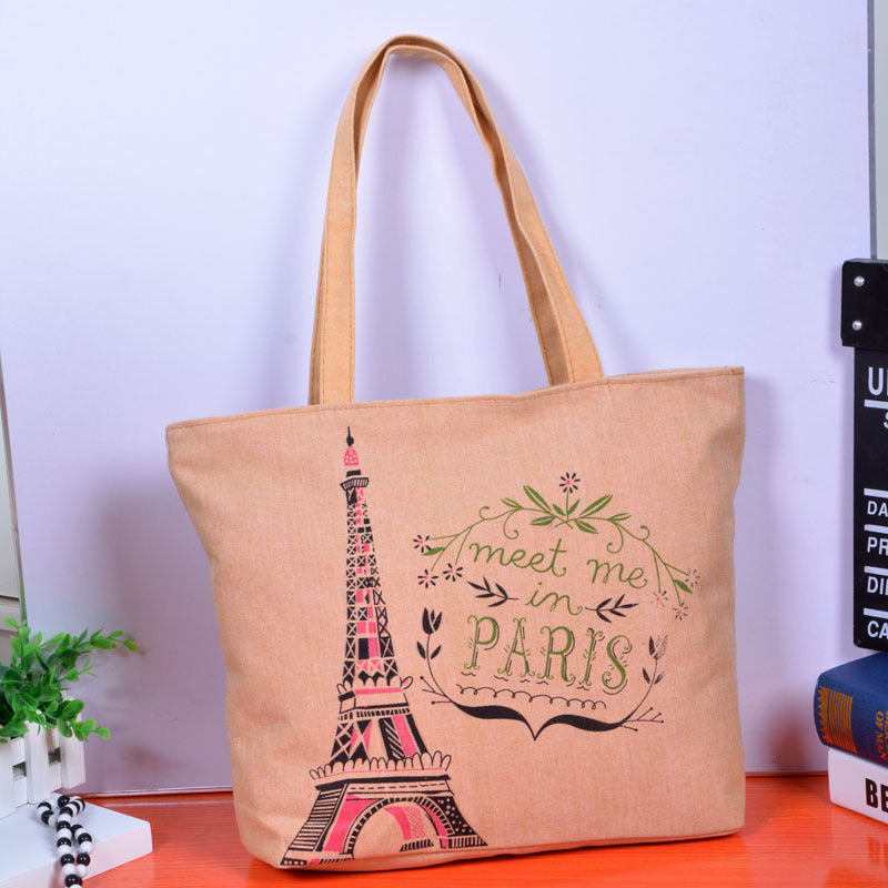 Canvas shoulder bag with Eiffel Tower and “meet me in PARIS” lettering on tan fabric