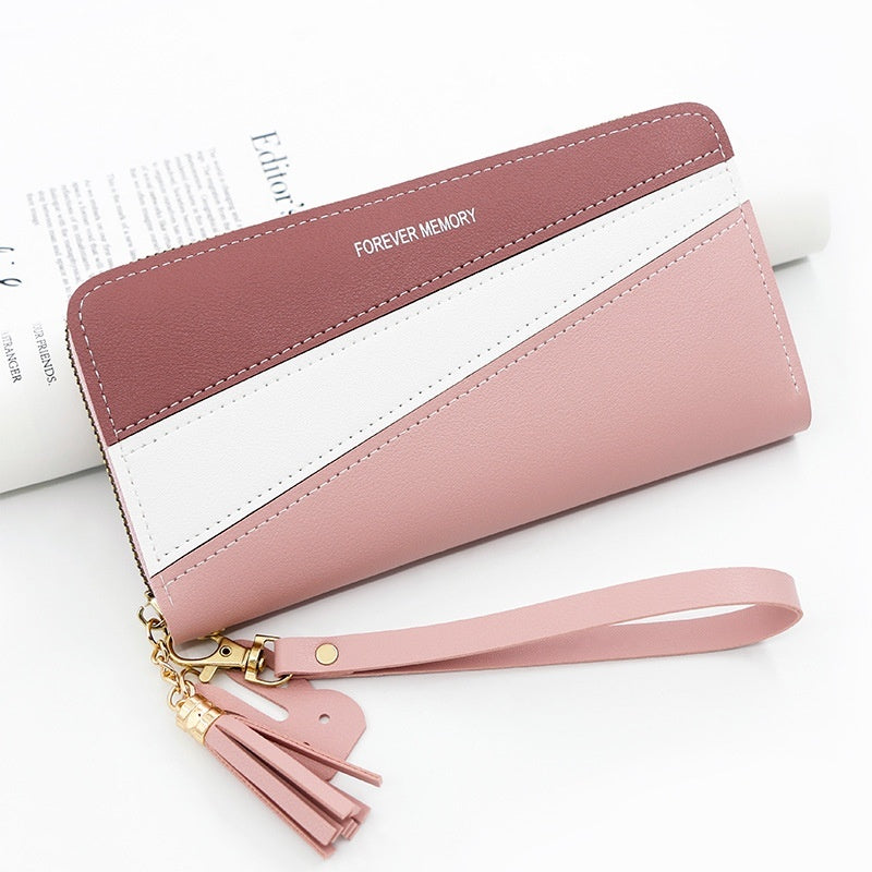 Long wallet with wrist strap, pink and white panels, tan stripe, tassel charm.