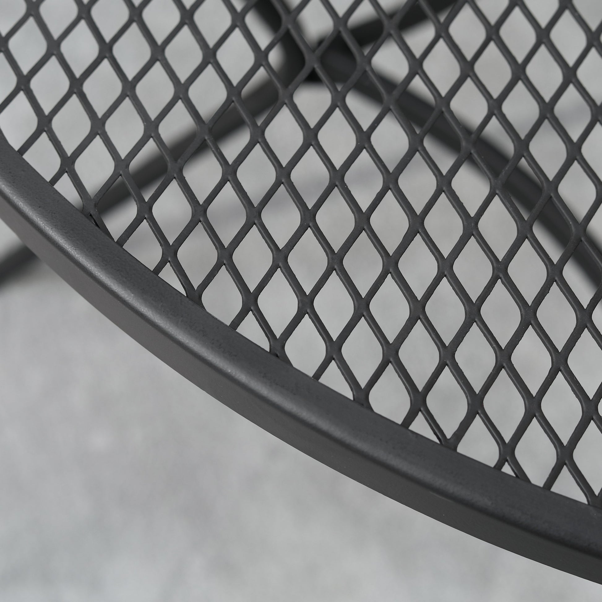 Black metal wire mesh detail on tabletop edge and curved support bar