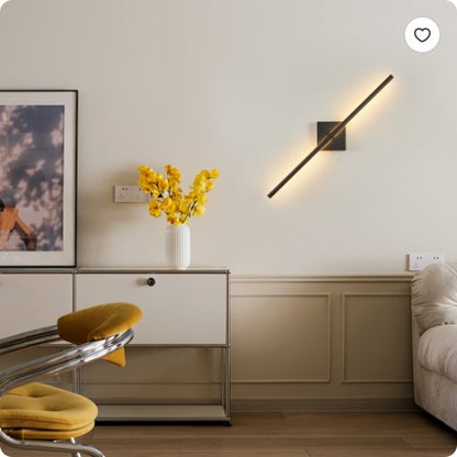 Black vertical LED wall sconce on wall, lit in warm tone