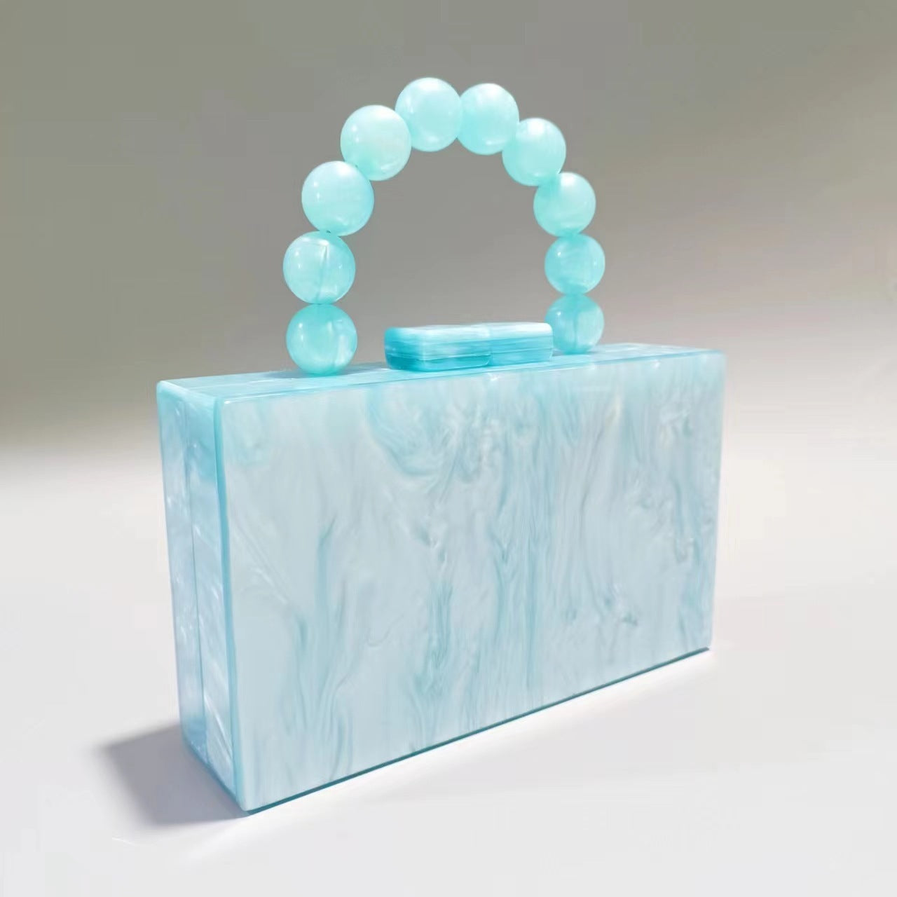 Light blue acrylic evening bag with round beaded handle and light blue top clasp