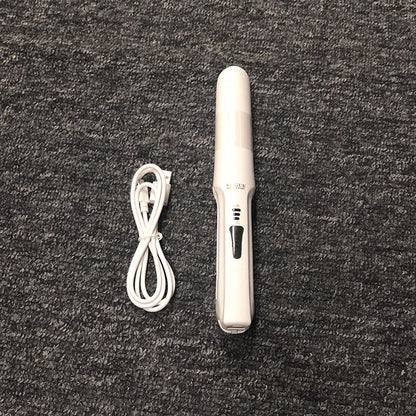 White hair straightener with cord on a dark textured surface