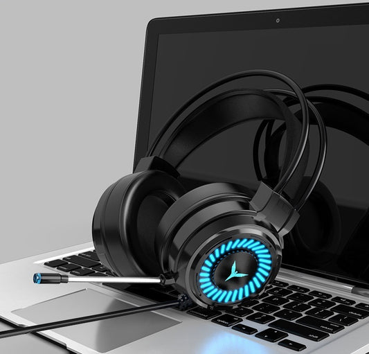 A pair of black King G60 gaming headphones with blue LED lights on the ear cups, resting on a laptop.