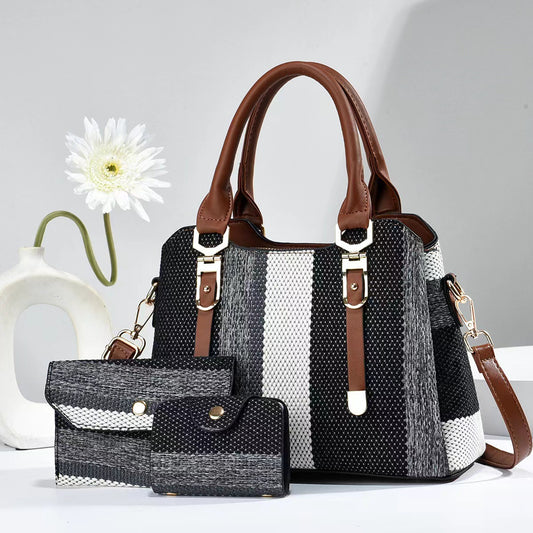 Black and white striped handbag with brown handles and accents on a light gray background