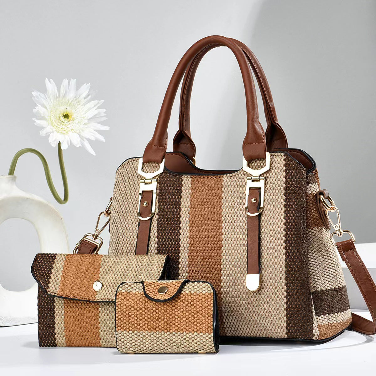 Large beige and brown striped canvas crossbody bag with brown handles and two matching accessory pouches.