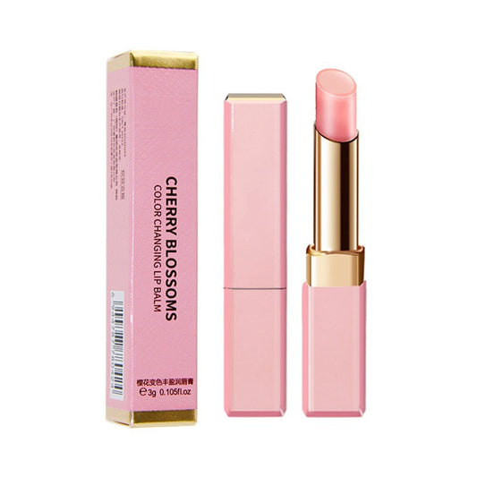 Pink lip balm with gold accents and packaging on a white background