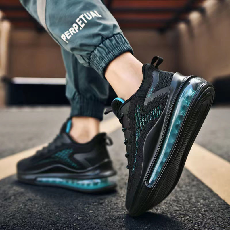 Black and teal athletic shoes on a person's feet with a blurred background