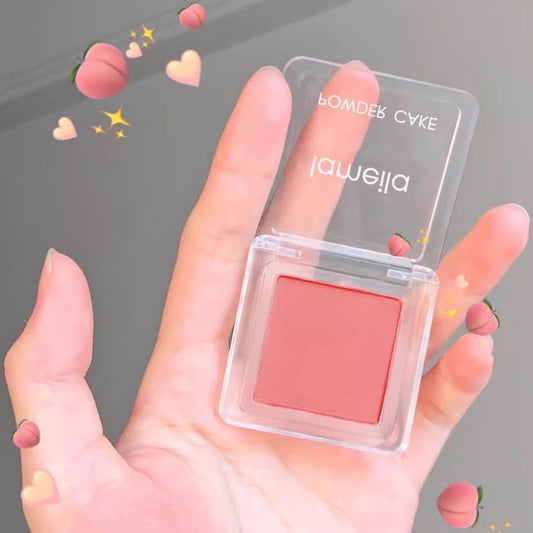Pink blush compact held in a hand with decorative elements on a gray background