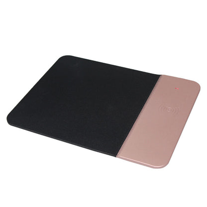A black rubber mouse pad with a wireless charging feature on the right side, where a smartphone is being charged.