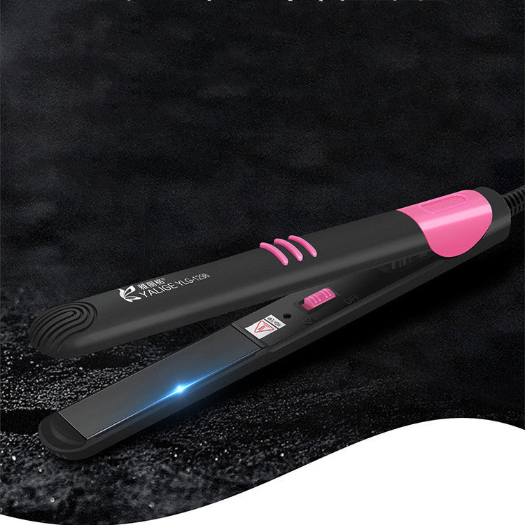 Black hair straightener with pink accents on a dark textured background