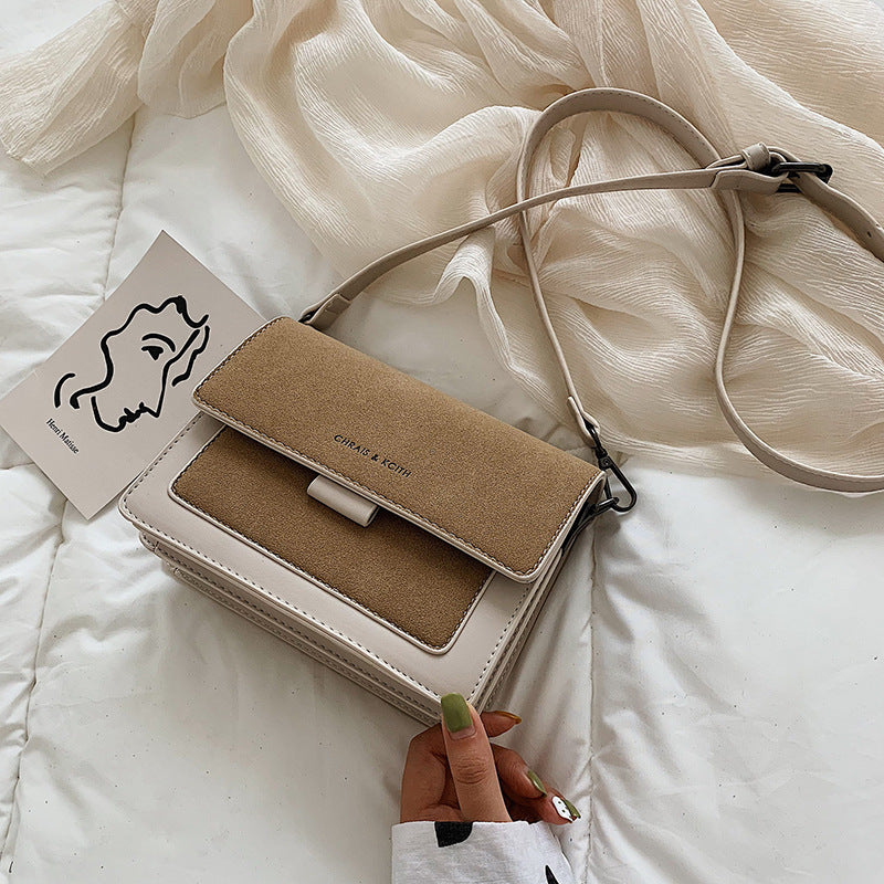 Small square crossbody bag with flap, brown top and white contrast body, adjustable strap
