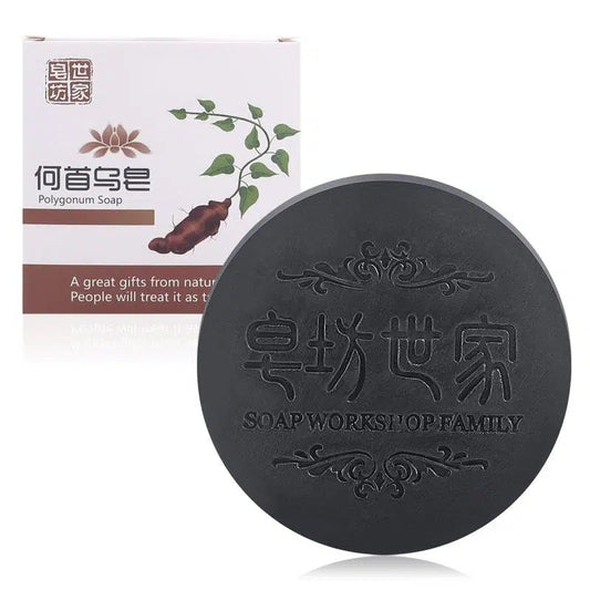 Black soap bar with branding and packaging on a white background