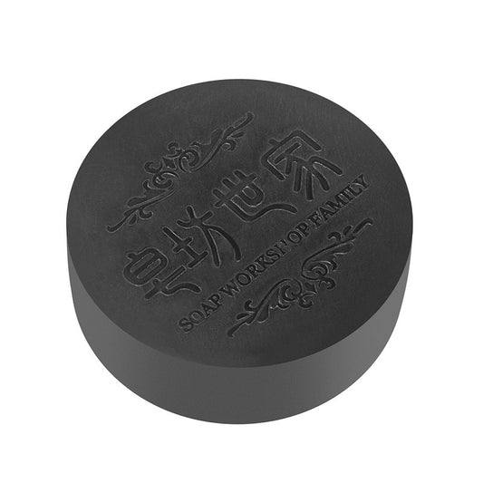 Black soap bar with embossed text on a white background