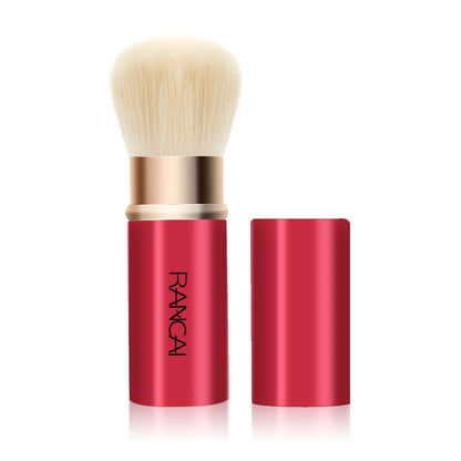 Makeup brush with red handle and gold accents on a white background