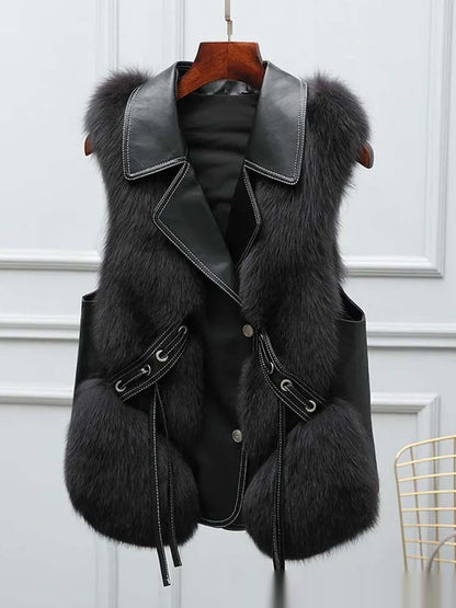 Black fur vest with leather accents on a hanger against a white background
