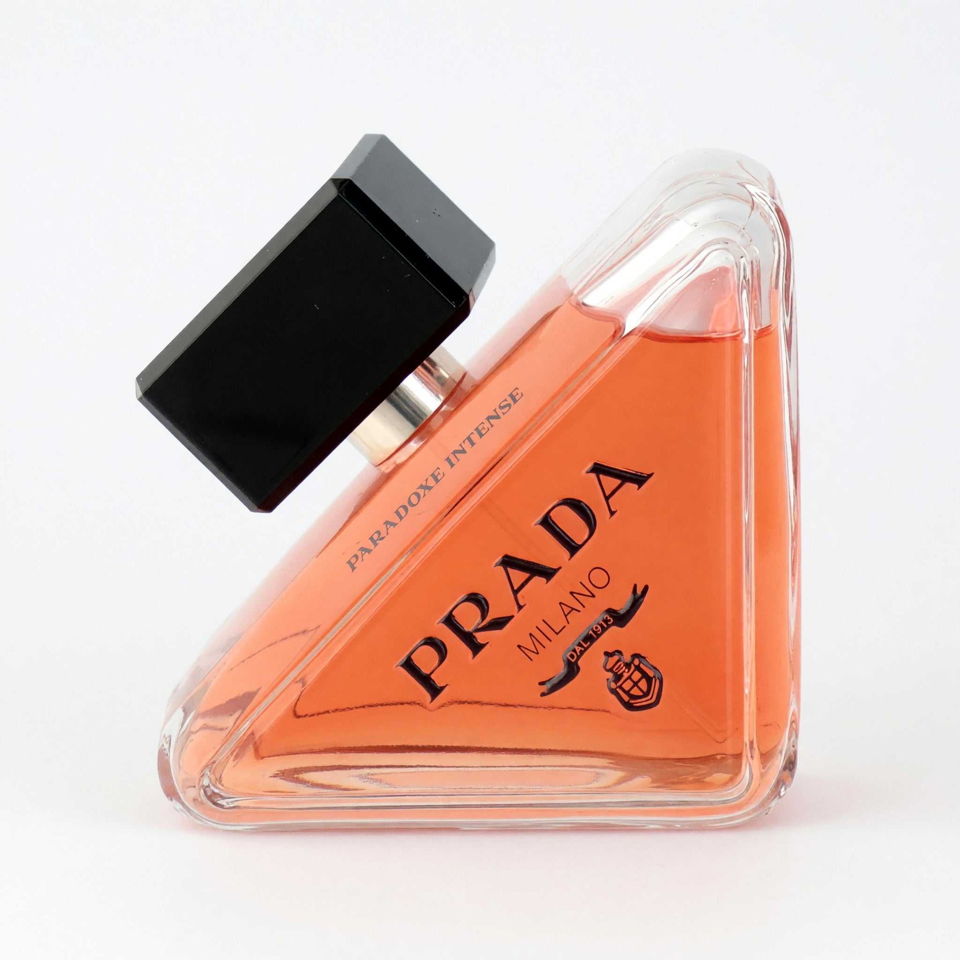 Orange triangular perfume tester bottle with black cap; Prada Paradoxe Intense