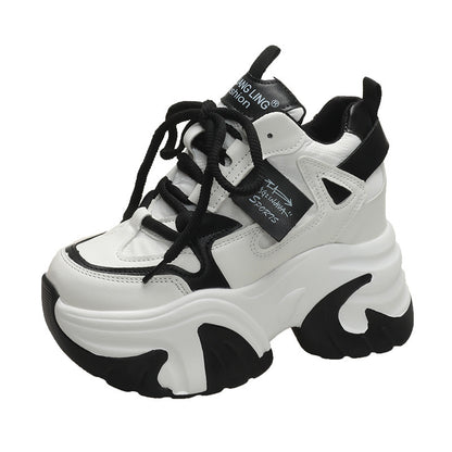 A pair of pink and white athletic shoes with a low-top design and mid heel height, displayed alongside a model wearing the shoes.