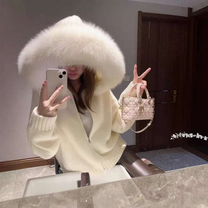 Person wearing a white fur-lined hooded coat taking a mirror selfie.