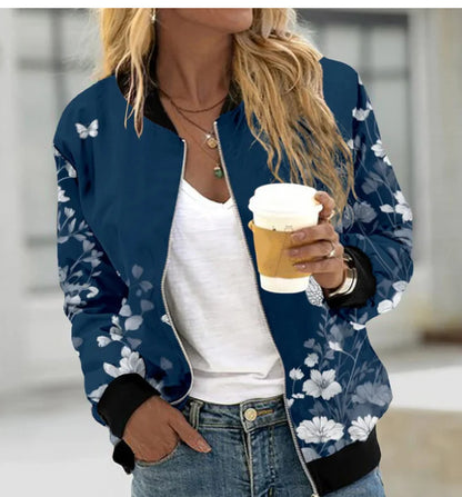 Person wearing a blue floral bomber jacket holding a coffee cup.